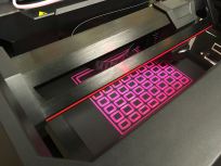 The MakerBot at work creating a bright pink keyguard to help our students activate their speech generating devices.
